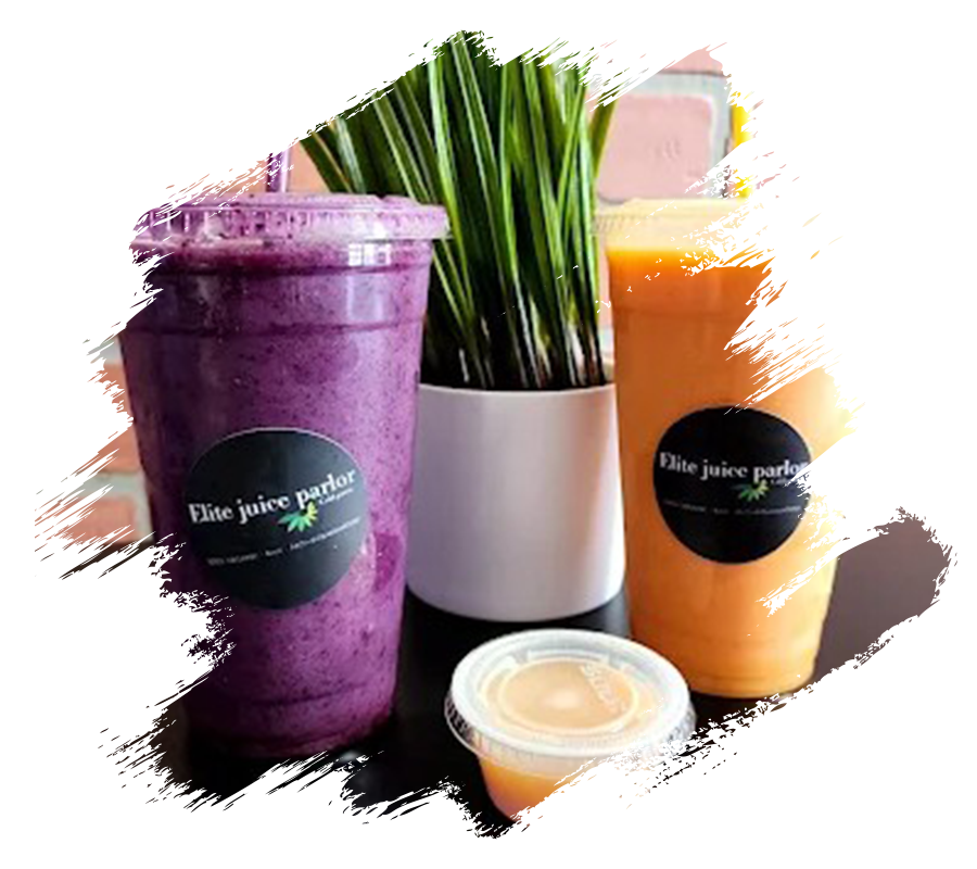 two brightly colored juice drinks sitting on a table with green plant behind them